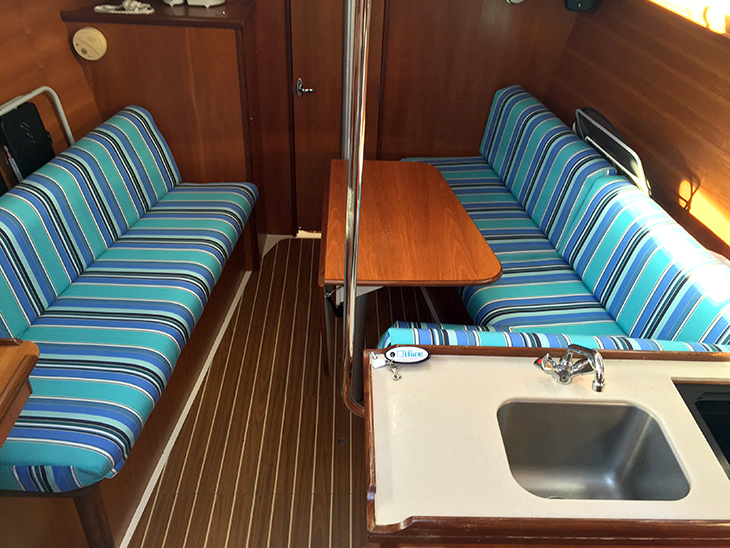 Boat cabin cushions made with an aqua- and blue-striped fabric.